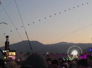 The Coachella Ferris Wheel and famous lit baloons over the crowd as the sun is setting in Indio.